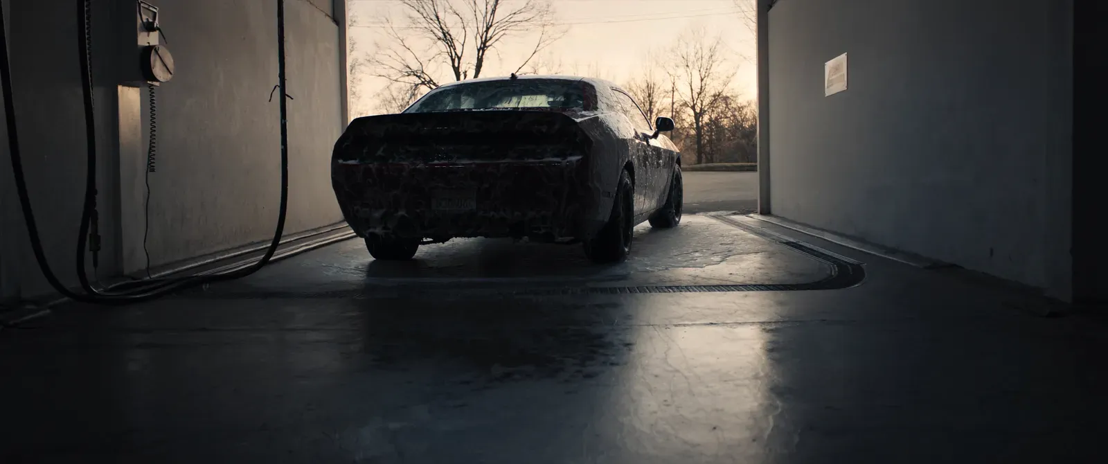 Dodge Muscle-Car mit Schaum in einer Waschbox bei Sonnenuntergang