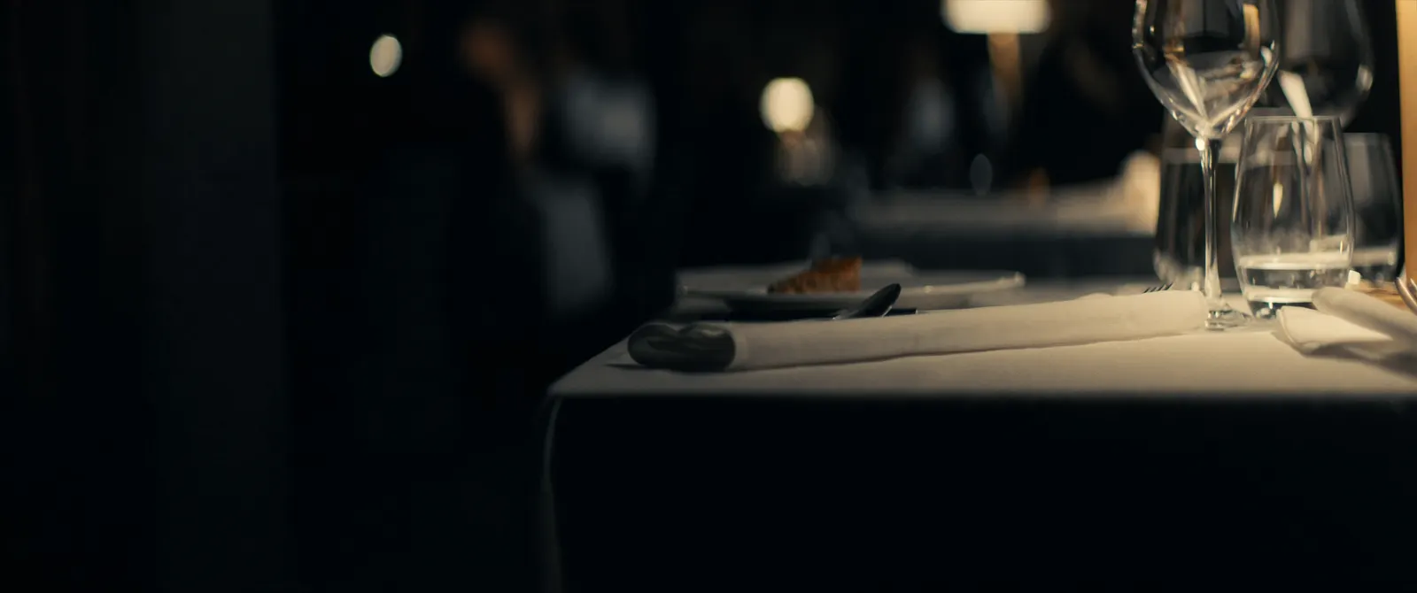 Elegant eingedeckter Restauranttisch mit Gläsern im warmen Licht
